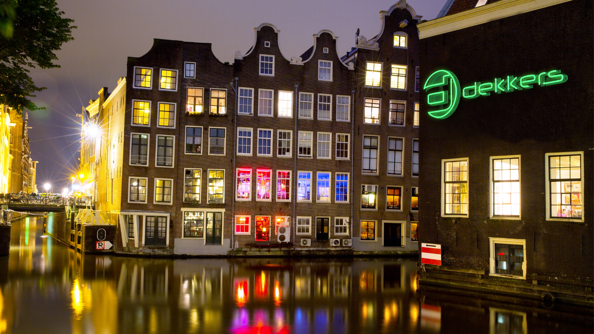 Dekkers' outdoor LED neon sign in amsterdam near a canal at night